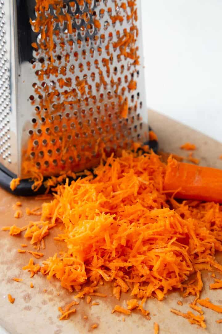 shredded carrots near a box grater.