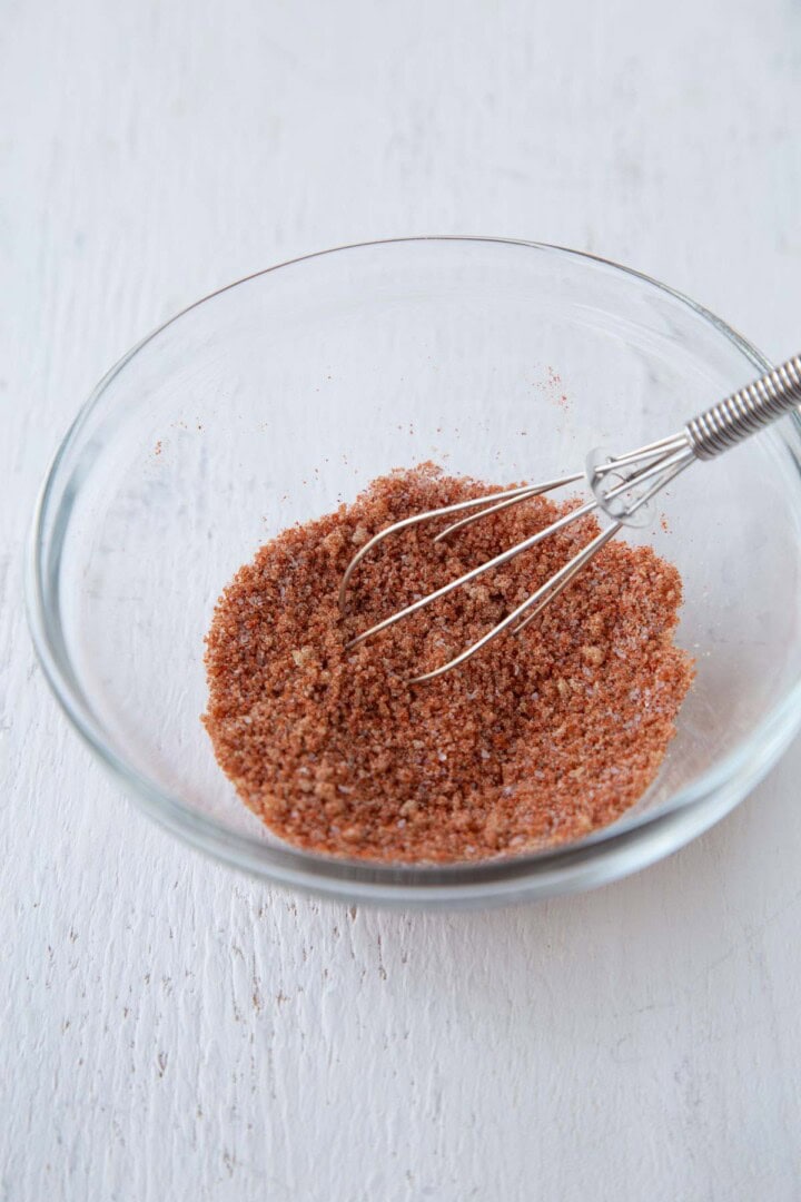 bbq spice rub with brown sugar and paprika in a small bowl with a small whisk.