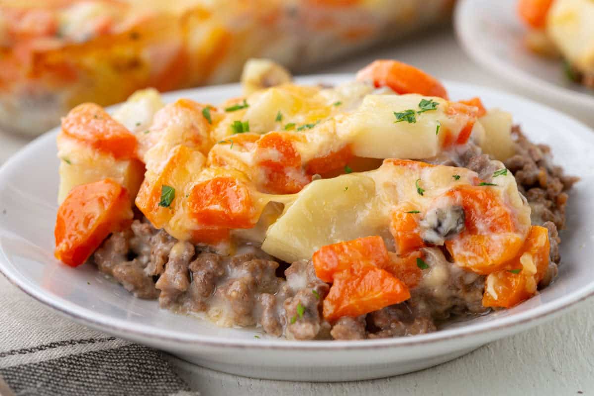 creamy hamburger potato and carrot mixture on a white plate.