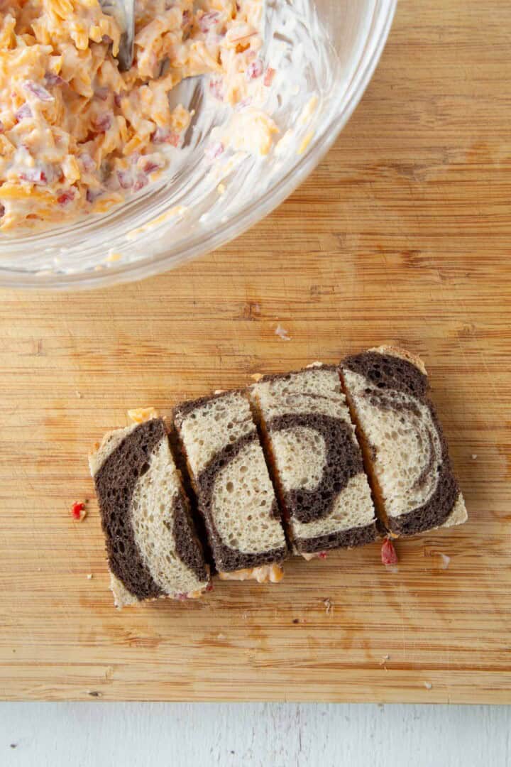 pimento cheese inside a slice of marble rye, cut into four rectangles.