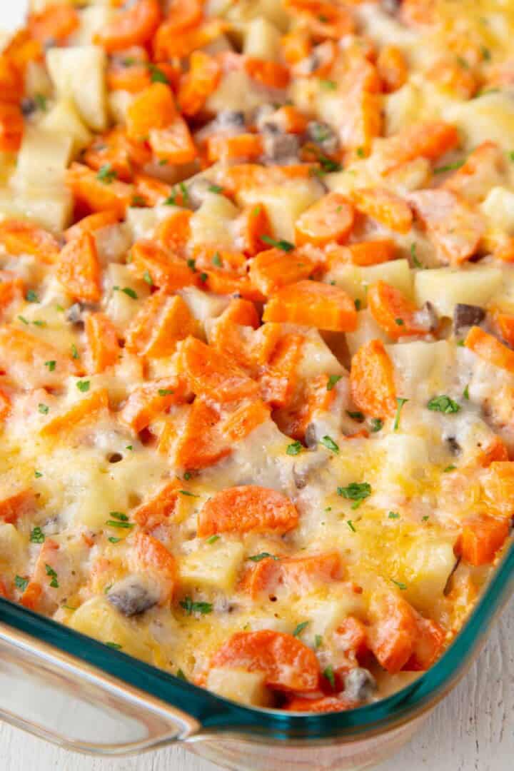 melted cheese on top of a baked casserole dish filled with ground beef, potatoes, and carrots in a creamy sauce.