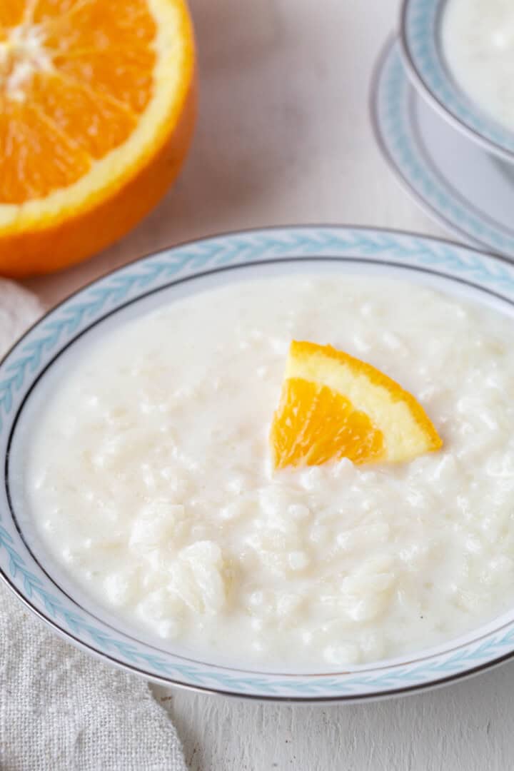 bowl of creamy white rice pudding with an orange peel on top.