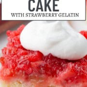 slice of rhubarb upside down cake with white cake on the bottom and a pink rhubarb topping, topped with whipped cream.