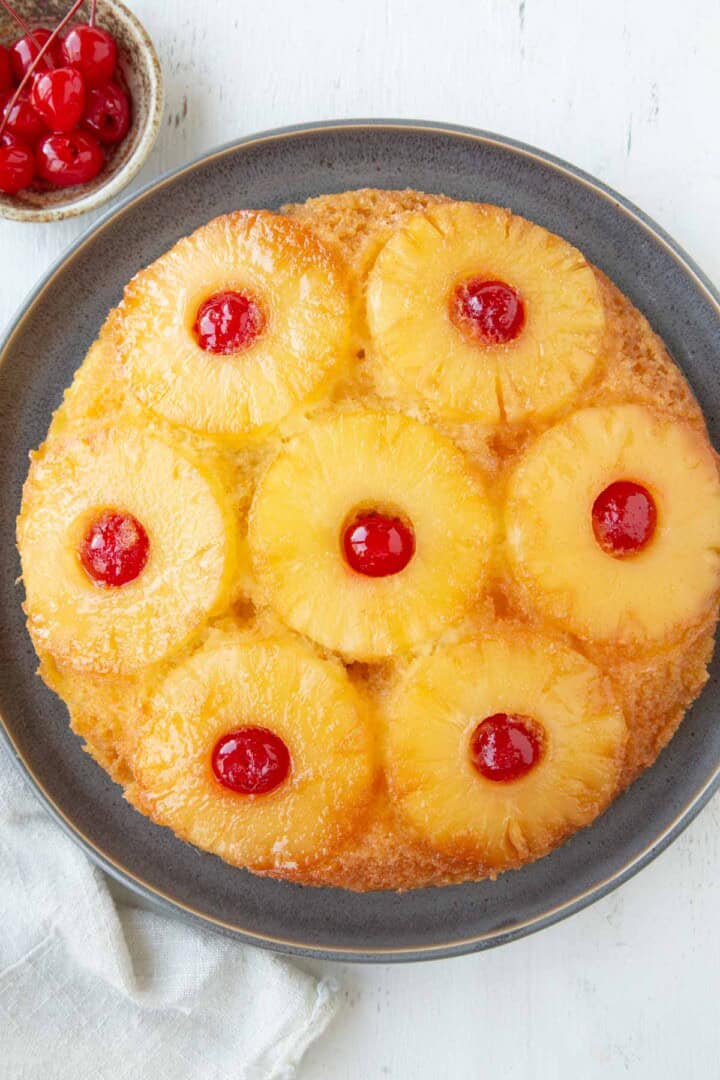 whole pineapple upside down cake with pineapple rings and cherries.