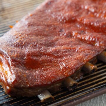 st louis style ribs on a baking sheet covered with a thin layer of bbq sauce.