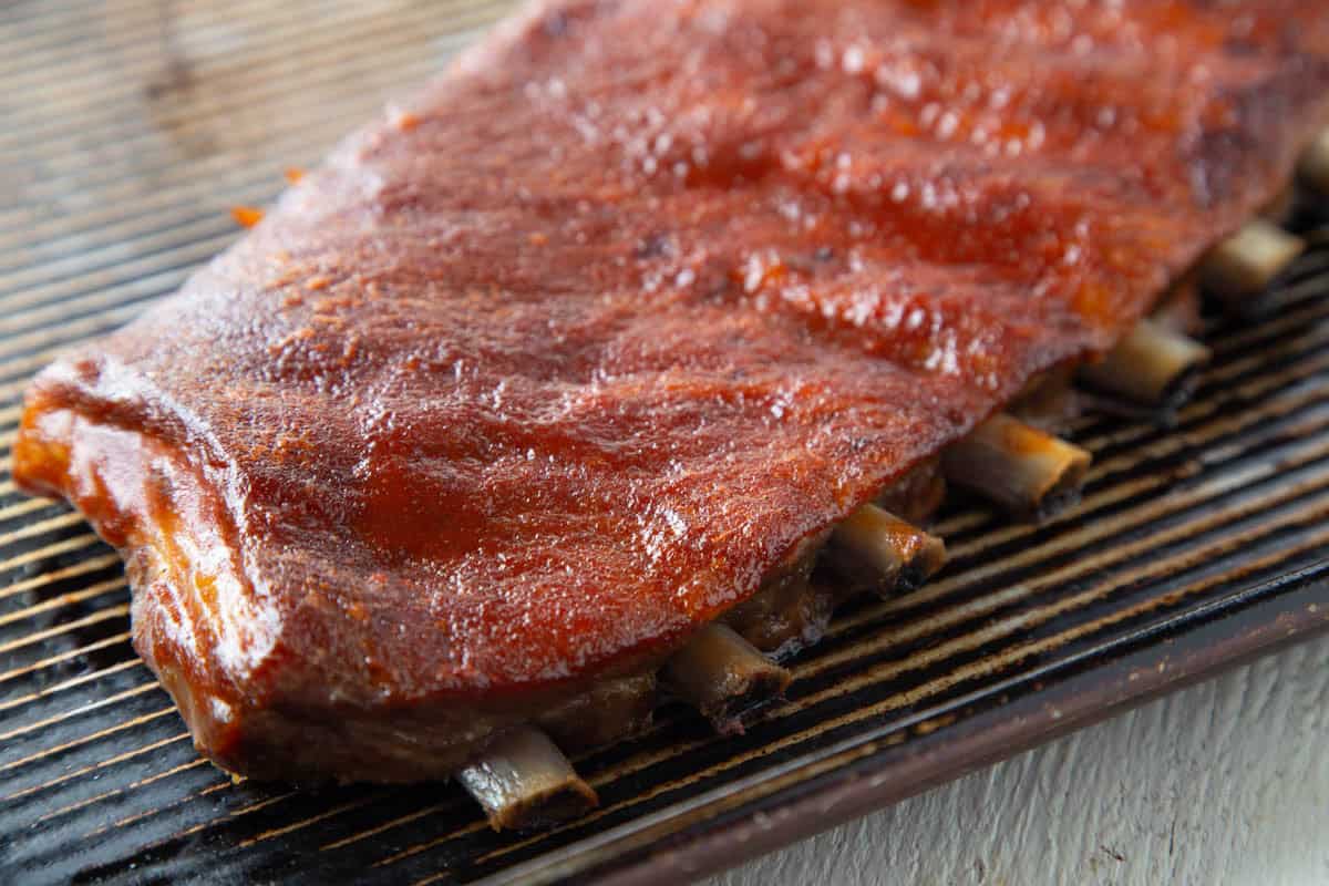 rack of st louis ribs covered in bbq sauce.