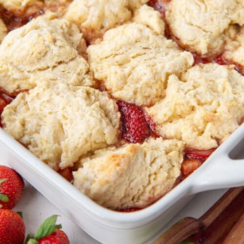 strawberry rhubarb cobbler topped with biscuits in a baking dish.