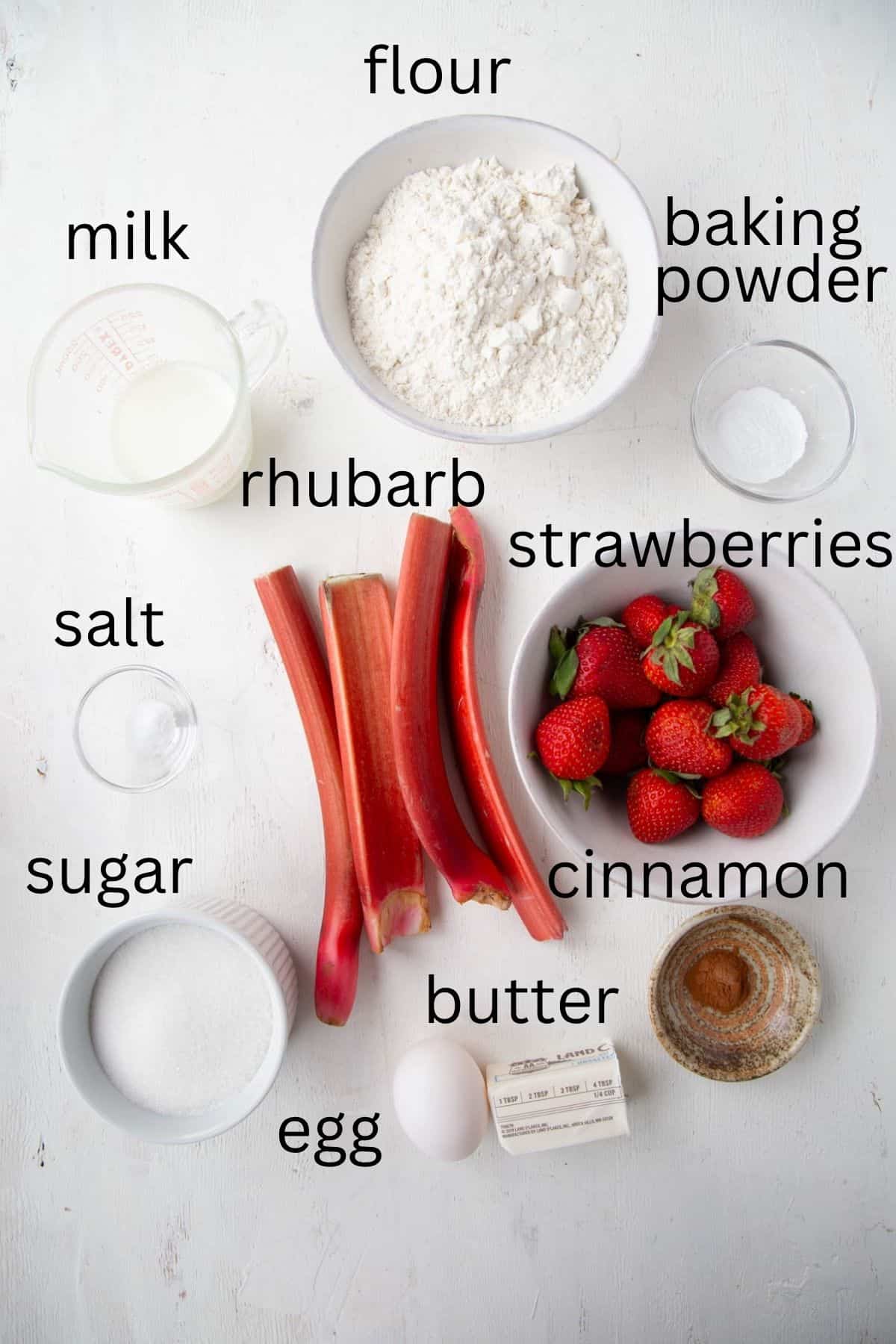 strawberries, rhubarb, sugar, flour, and more ingredients for cobbler.