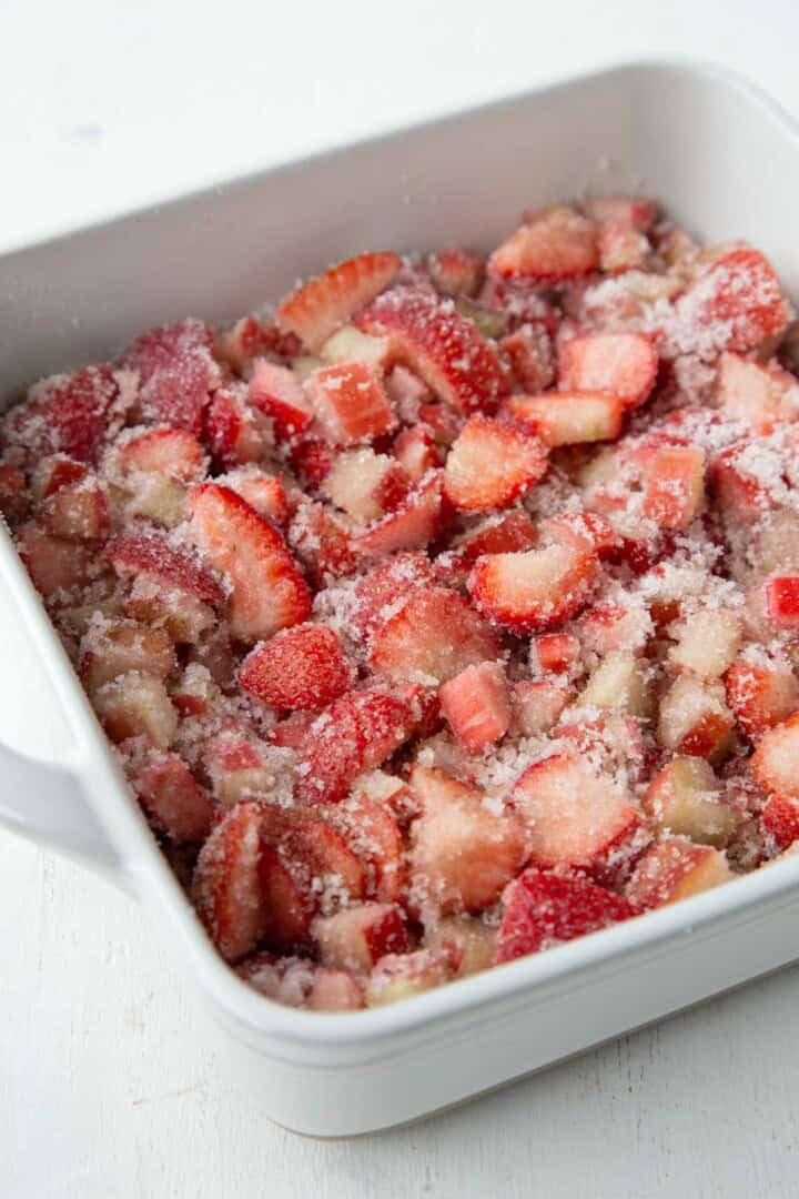 strawberries, rhubarb, and sugar in a baking dish.