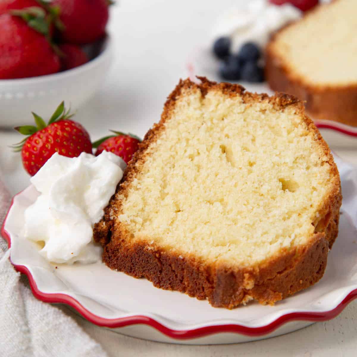 slice of 1234 cake on a decorative plate with a whipped cream and strawberry garnish.