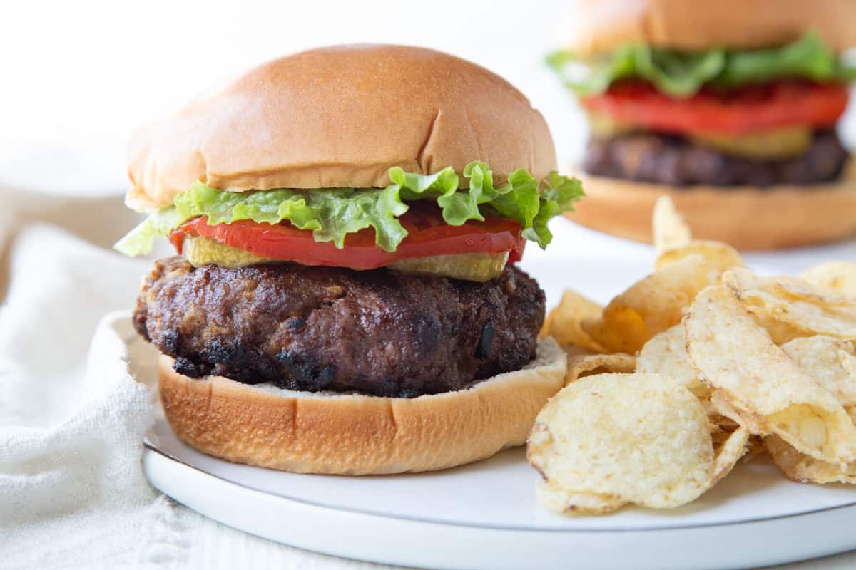 burger made with french onion soup on a bun with tomato and lettuce.