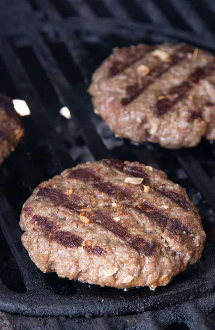 cooked burger patties on a grill.