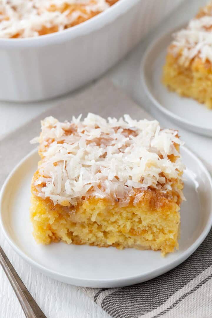 slice of yellow cake topped with a sticky coconut glaze.
