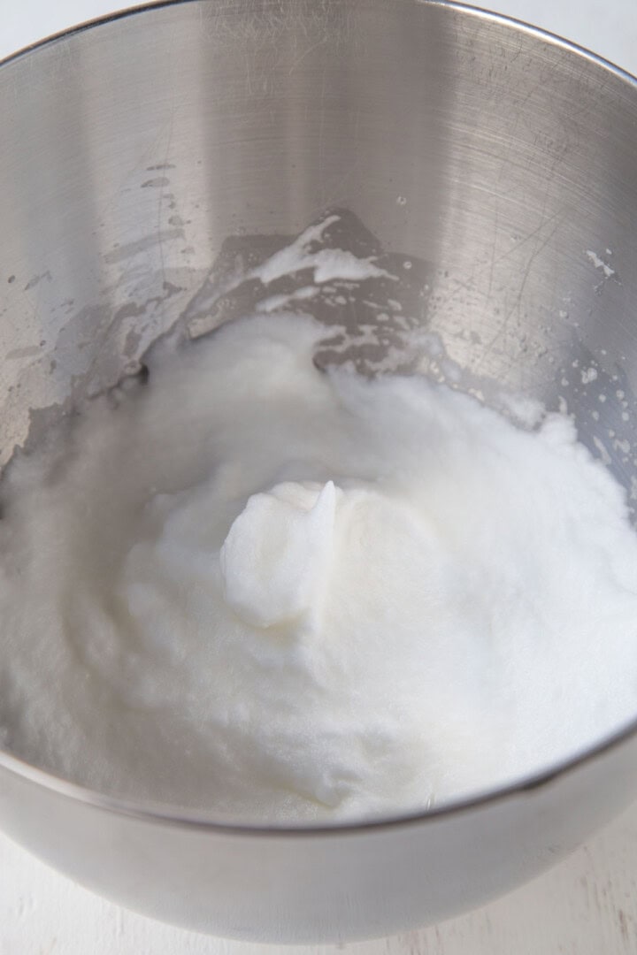 whipped egg whites in a metal bowl.