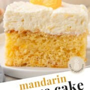 slice of mandarin orange cake topped with cool whip and a mandarin orange slice.