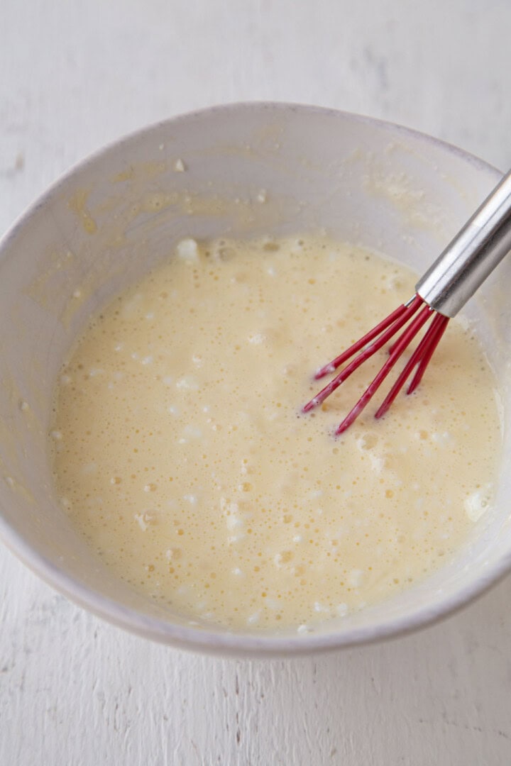 cottage cheese and egg mixture in a bowl with a whisk.