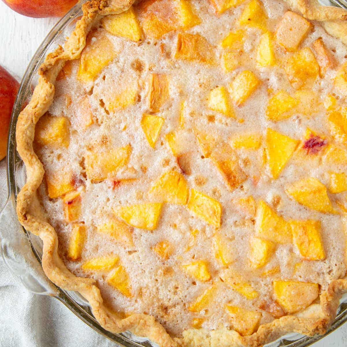 whole peach cream pie with chunks of peaches in a cinnamon cream, in a flaky pastry crust.