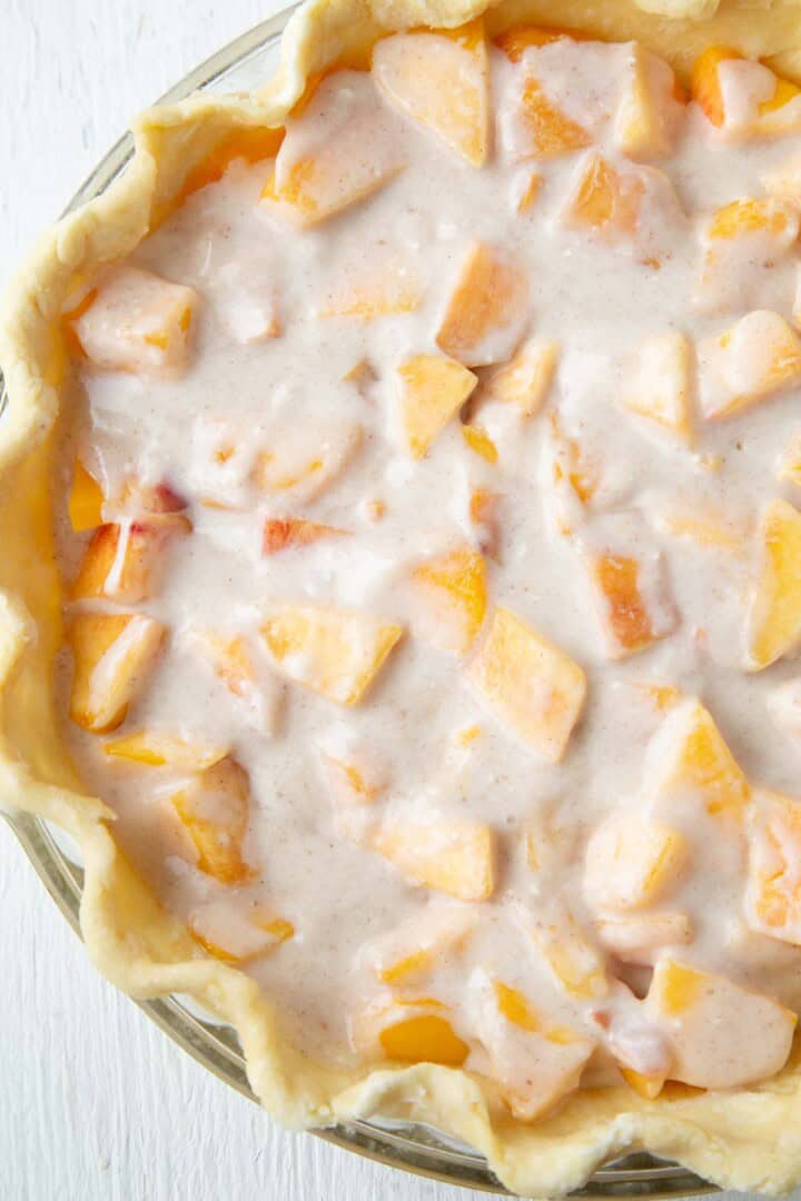 chopped peaches covered with a cinnamon cream mixture in a pie crust.