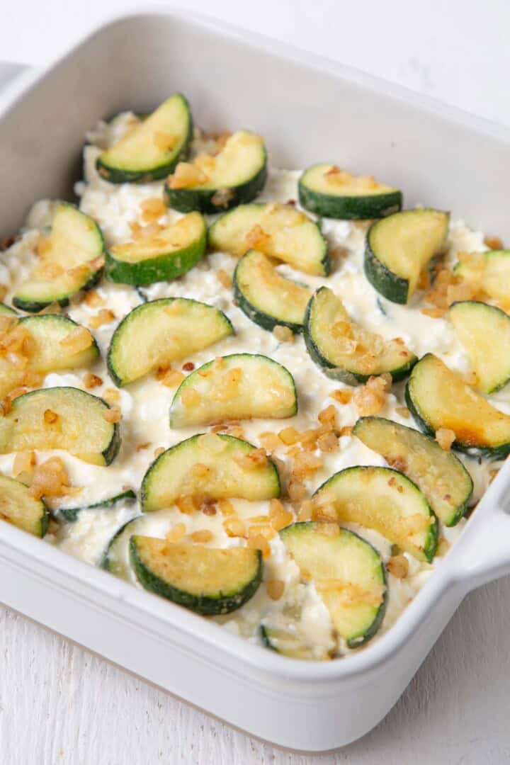 zucchini over a cottage cheese mixture in a casserole dish.