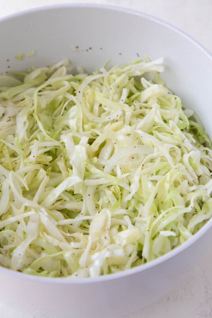shredded cabbage and onions with a vinegar dressing on it.