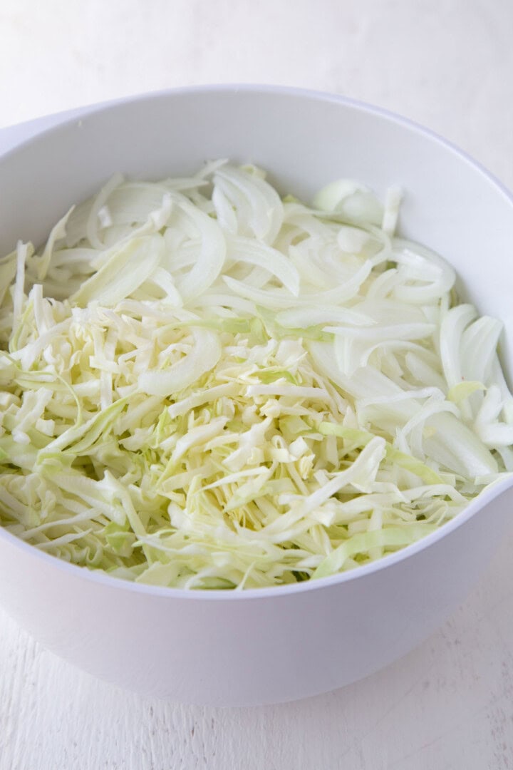 shredded cabbage and onions in a large bowl.