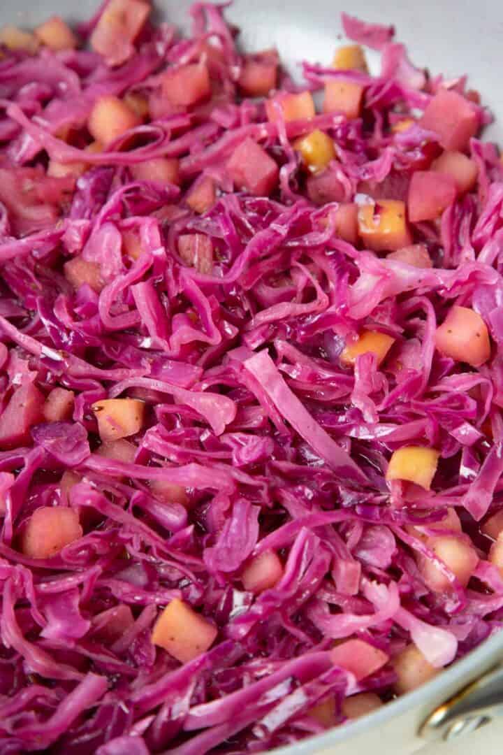 cooked purple cabbage and apples in a sauté pan.