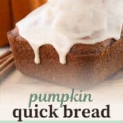 whole loaf of pumpkin bread with a cinnamon glaze on top and dripping down the sides.