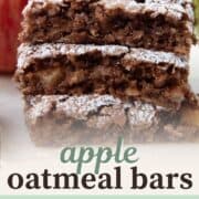 apple oat bars stacked on top of each other, topped with powdered sugar.