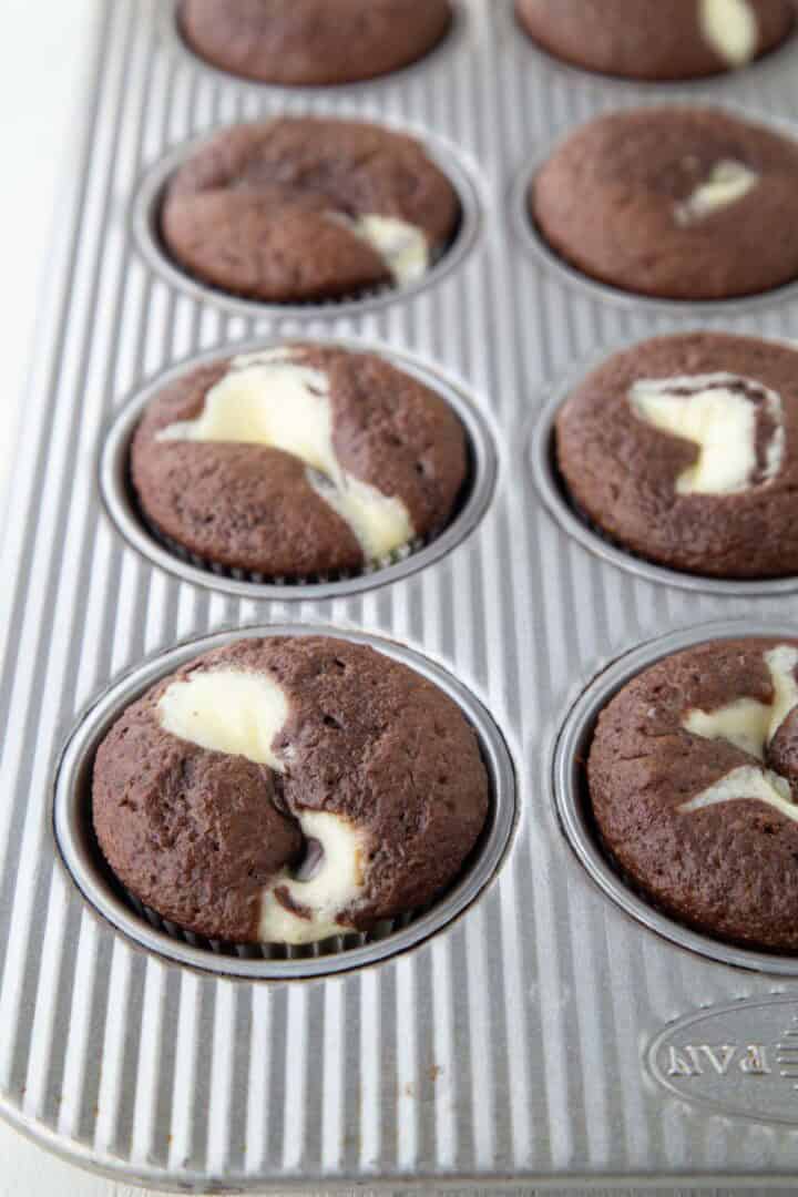 baked black bottom cupcakes with chocolate cake and a swirl of cream cheese in the center.