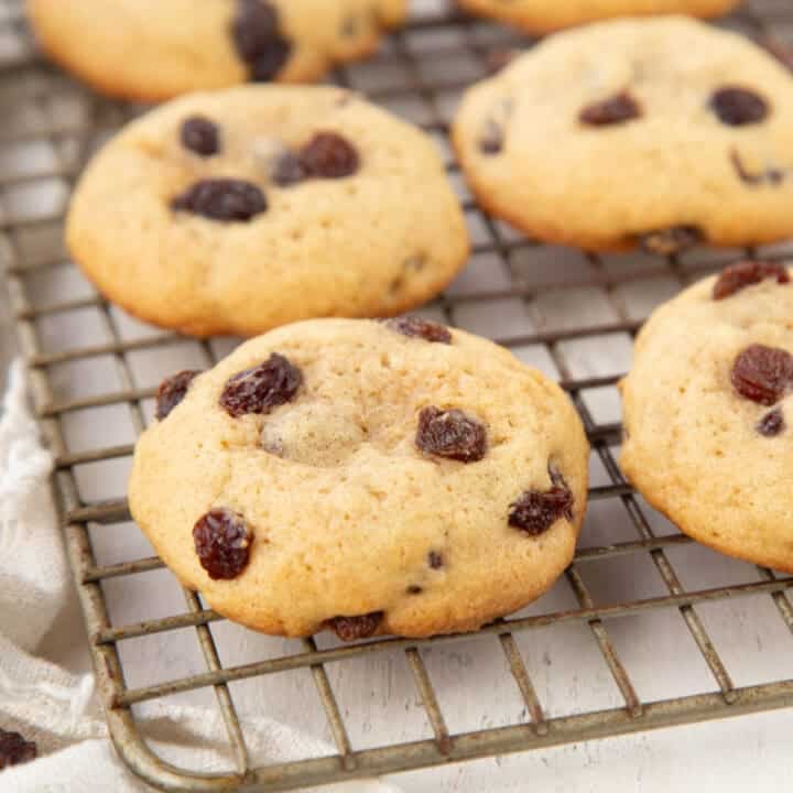 hermit cookies topped with raisins on a wire baking rack.