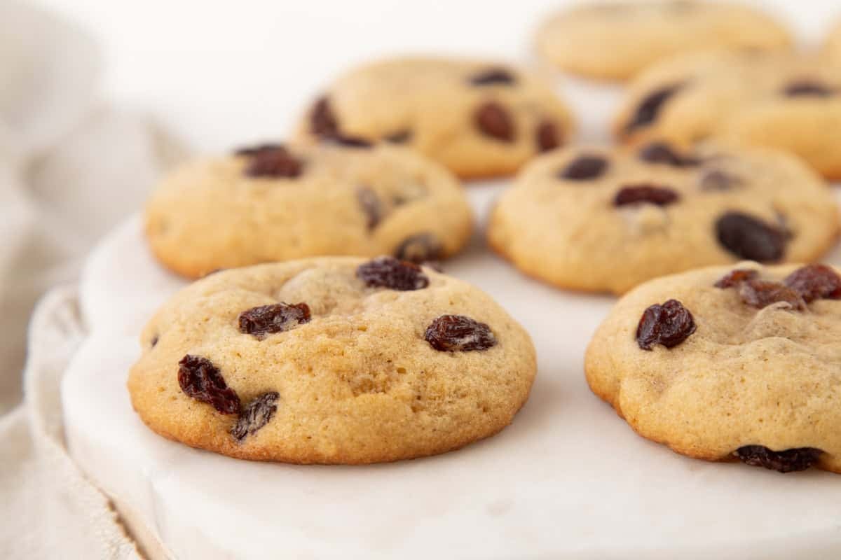 hermit cookies with raisins on top on a white serving platter.