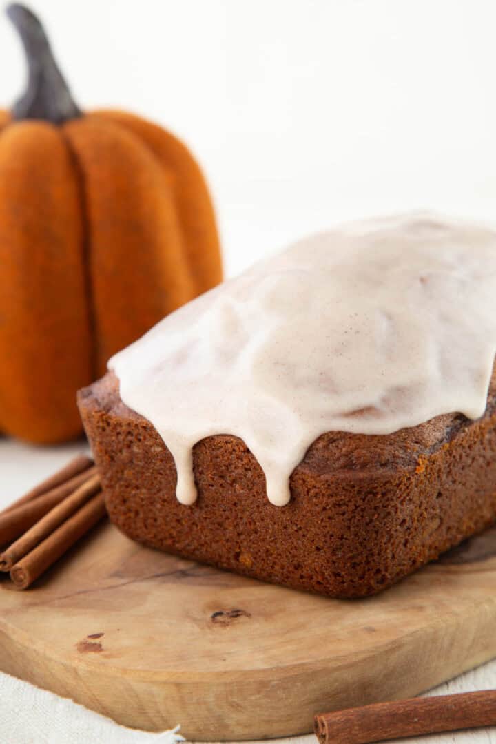 loaf of pumpkin bread with glaze dripping down off the top.
