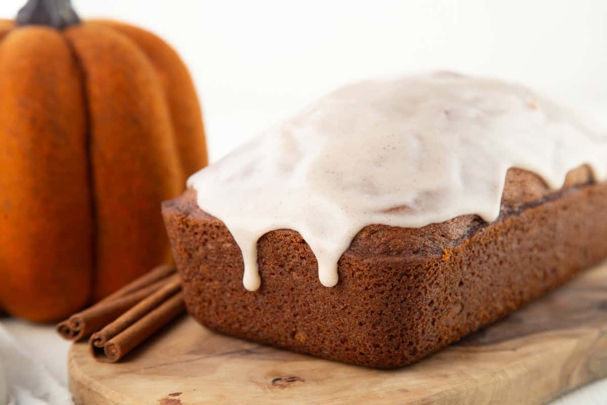 whole loaf of pumpkin bread with glaze on top and dripping down the sides.