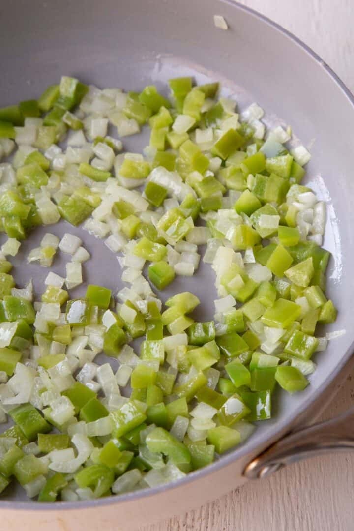 sautéed and chopped bell peppers and onions in a skillet.