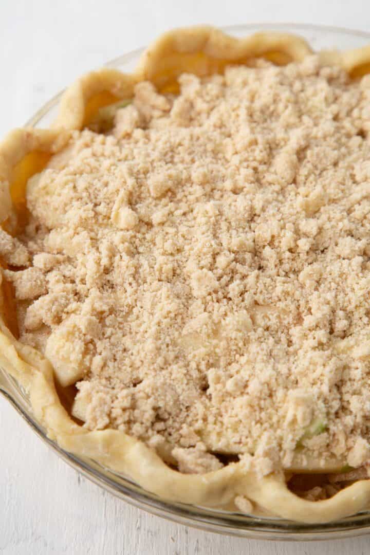 unbaked dutch apple pie with a crumbly brown sugar and butter topping.